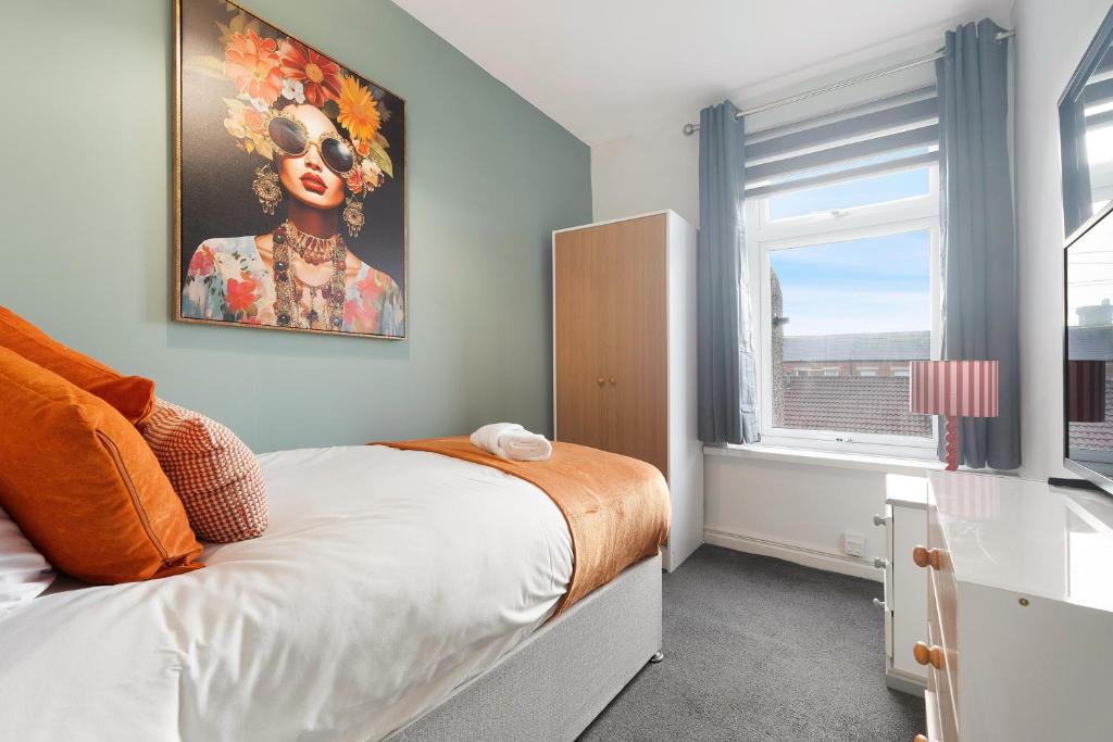 a bedroom with a bed and a painting of a woman at 4BR Mitchell Street Apartment Sleeps 6 by Stay With Us in Shield Row