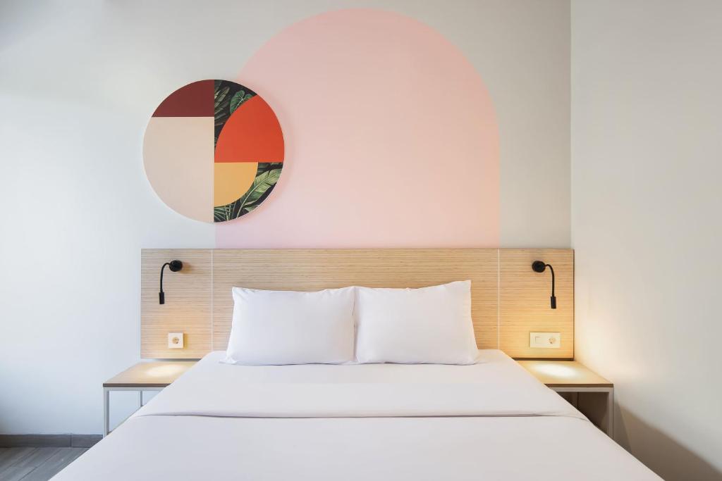 a bedroom with a white bed with a mirror on the wall at Cove Limora in Bandung