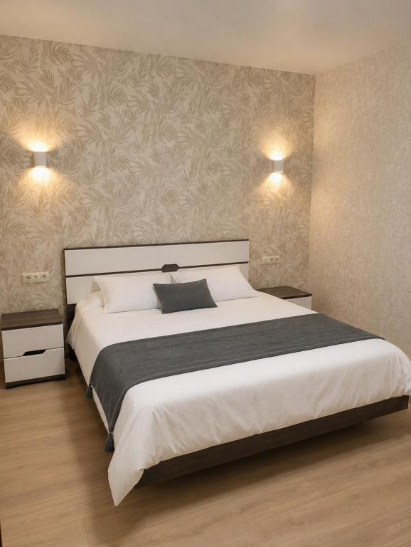 a bedroom with a large white bed and two lights at Atlant luxury Big Family Perlina Apart on Golovna поряд з ТЦ Депот in Chernivtsi