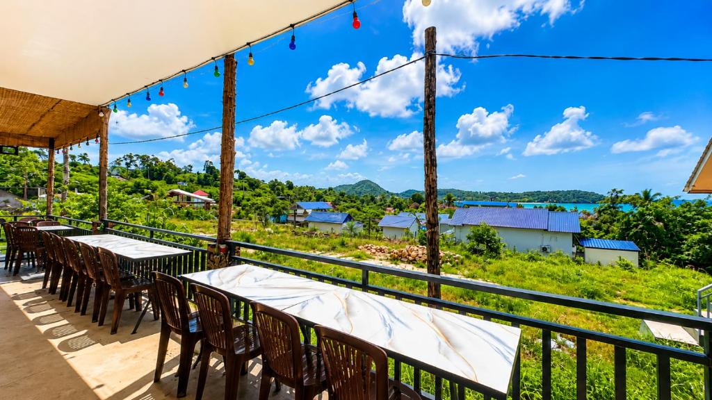 a balcony with tables and chairs and a view of the ocean at Antalya Hostel Bar & Restaurant in Kaôh Rŭng (3)