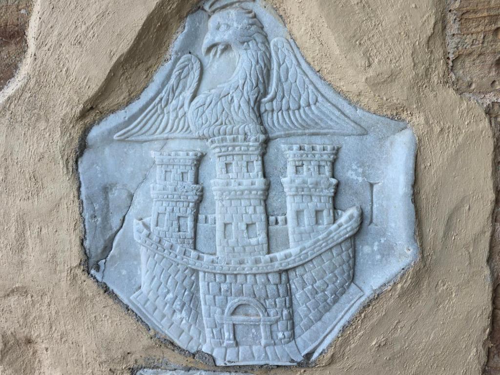 a stone relief of a castle on a wall at Arhodico Simou mansion in Kambos