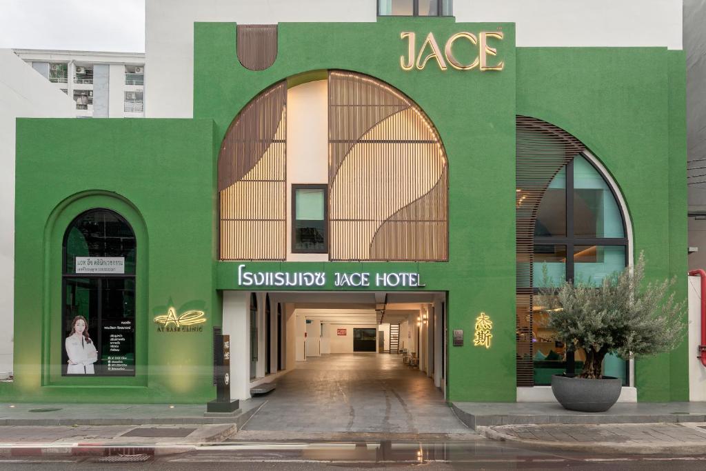 ein grünes Gebäude mit einem Eingang zum Alezbestosbestos Ace Hotel in der Unterkunft Jace Ratchada Hotel in Bangkok