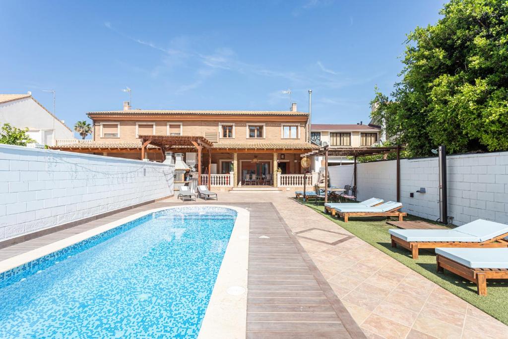 a house with a swimming pool in front of a house at Marenostrum Villa in Valencia