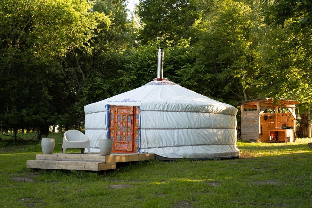 a yurt sitting in a field with a chair at Countryside yurt near Tõrva in Jõgeveste