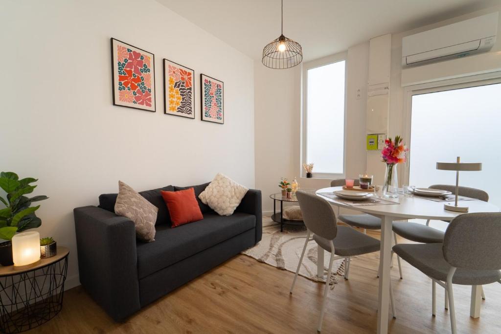 a living room with a couch and a table at T2 moderne Mon Toit in Mont-de-Marsan