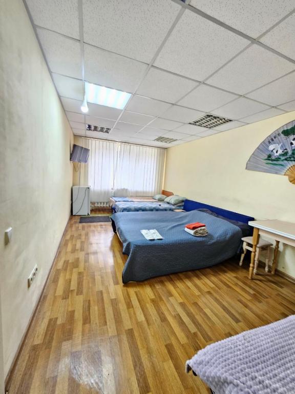 a room with two beds and a table in it at Tik-Tak Mini-Hotel in Cherkasy