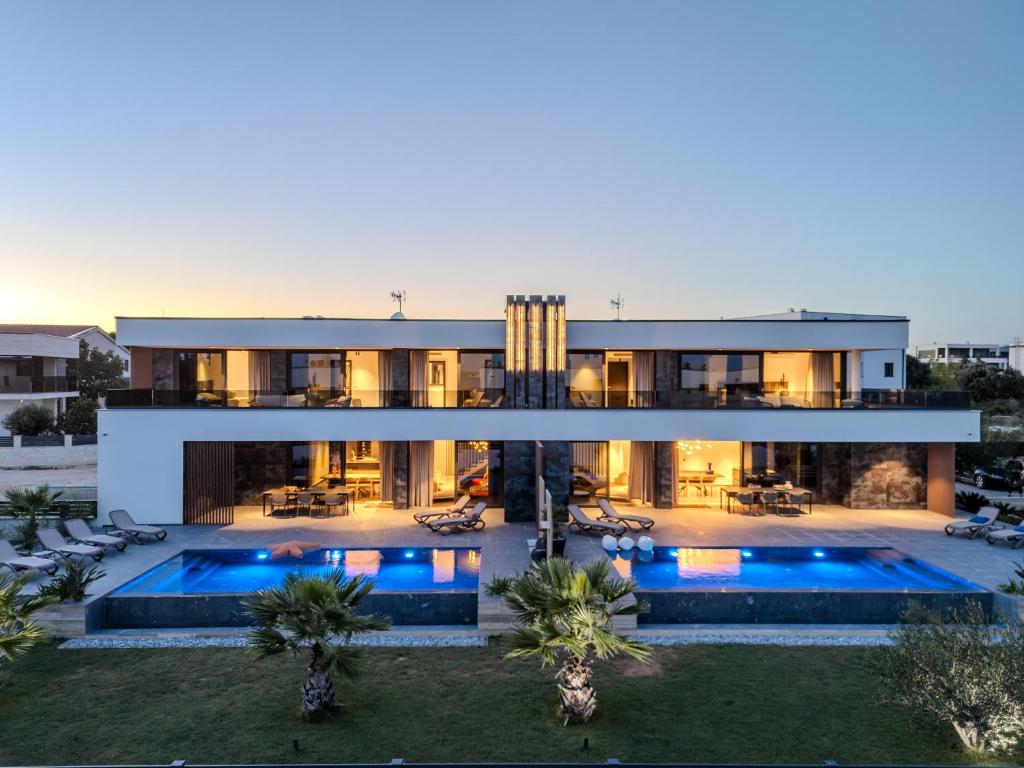 a villa with a swimming pool at dusk at Villa Sika in Vir
