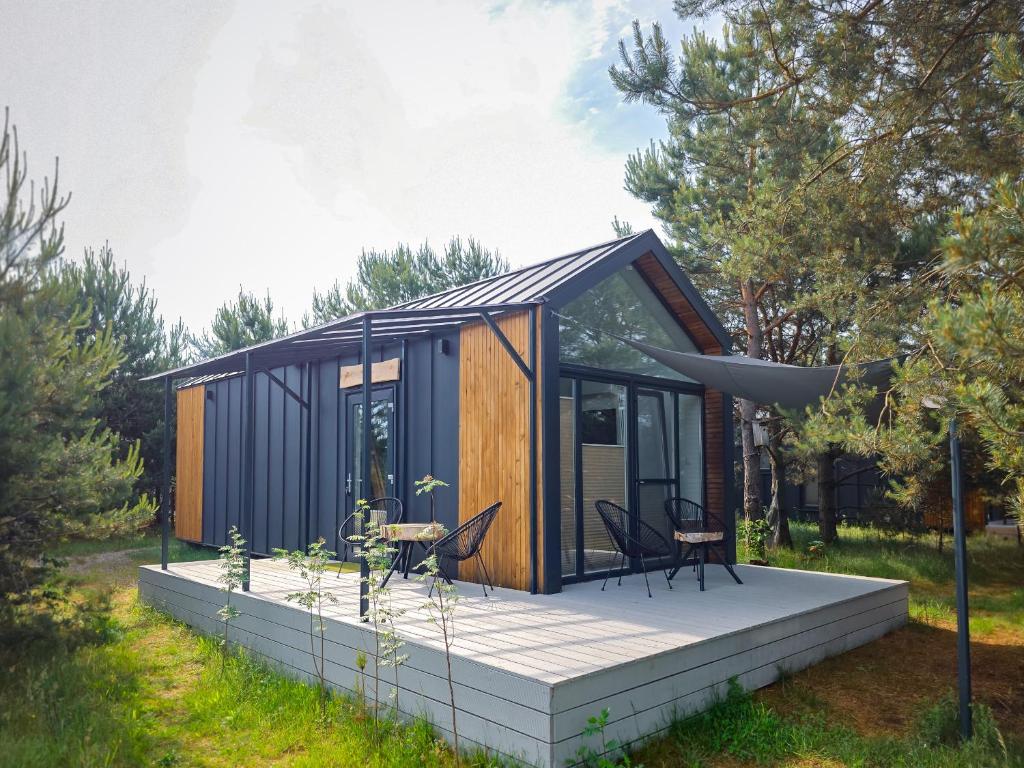 a tiny house with a deck in a garden at Dywanowy Zakątek in Sominy