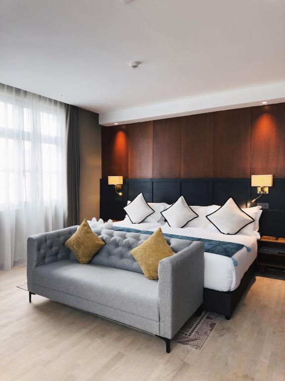 a bedroom with a large bed and a couch at Moon Hotel in George Town