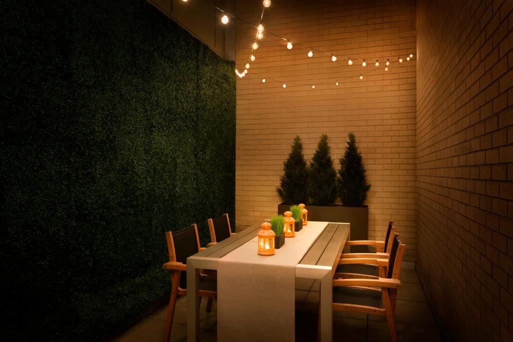 a dining room with a table with chairs and lights at Hotel Le Soleil by Executive Hotels in Vancouver
