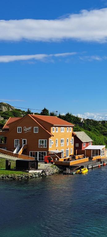 a building on the water next to a dock at Røvær Havhotell in Røvær
