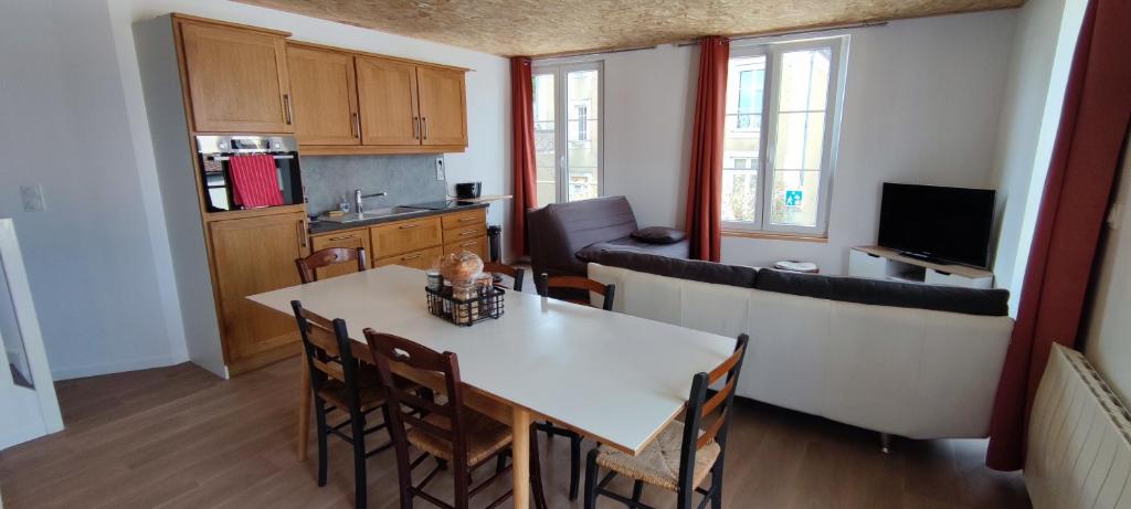 a kitchen and living room with a table and chairs at DUPLEX DE LA MOTTE in Beaumont-sur-Sarthe