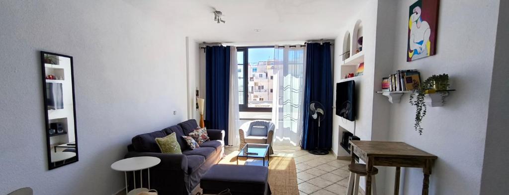 a living room with a couch and a window at Apartamento playero Privado WiFi- MorroJable in Morro del Jable