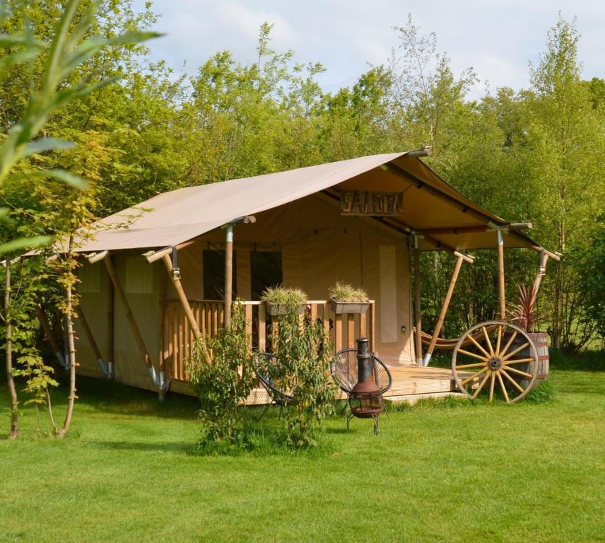 a tent with a wheel in a yard at Wild Wild West Saloon in Paasloo