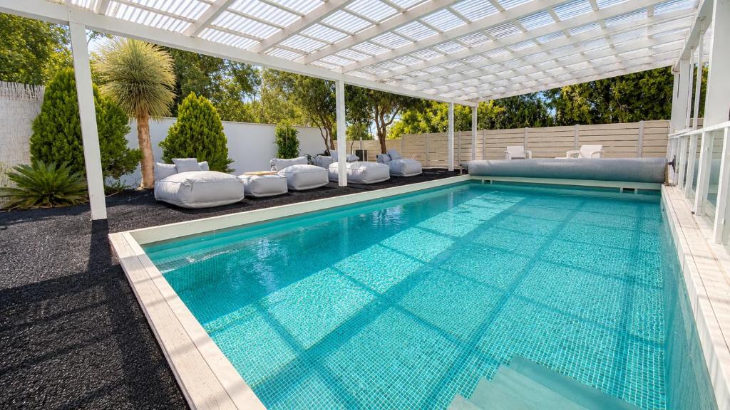 a swimming pool with a pergola and a swimming pool at Liberty spa & suites - שלוש סוויטות ושתי ווילות מהממות עם בריכה פרטית in Manot