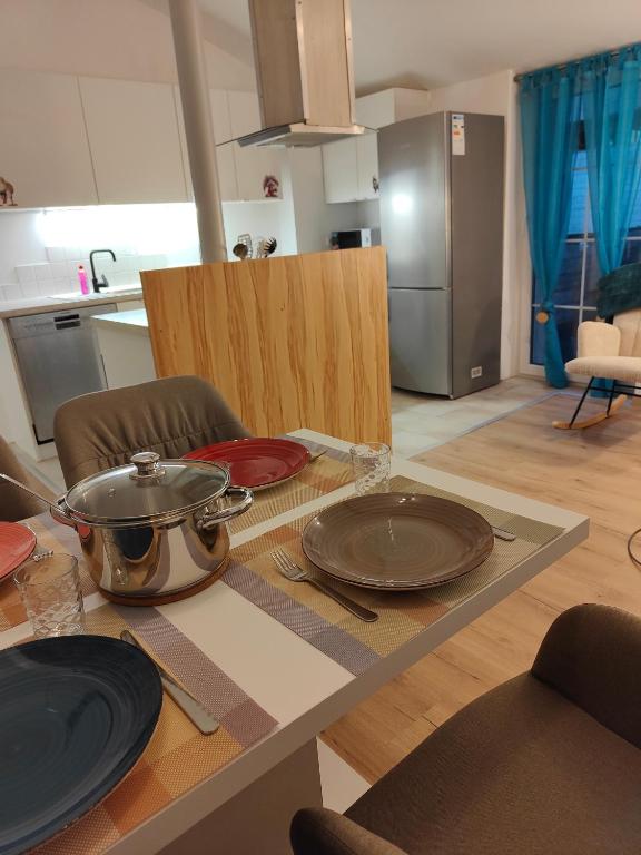 a kitchen with a table with a pot and plates on it at Ferienwohnung Einsiedler - für 4 Personen mit Terrasse und Grill in Windisch Minihof