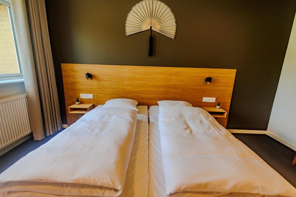 a bed with two white beds in a room at Danhostel Tønder in Tønder