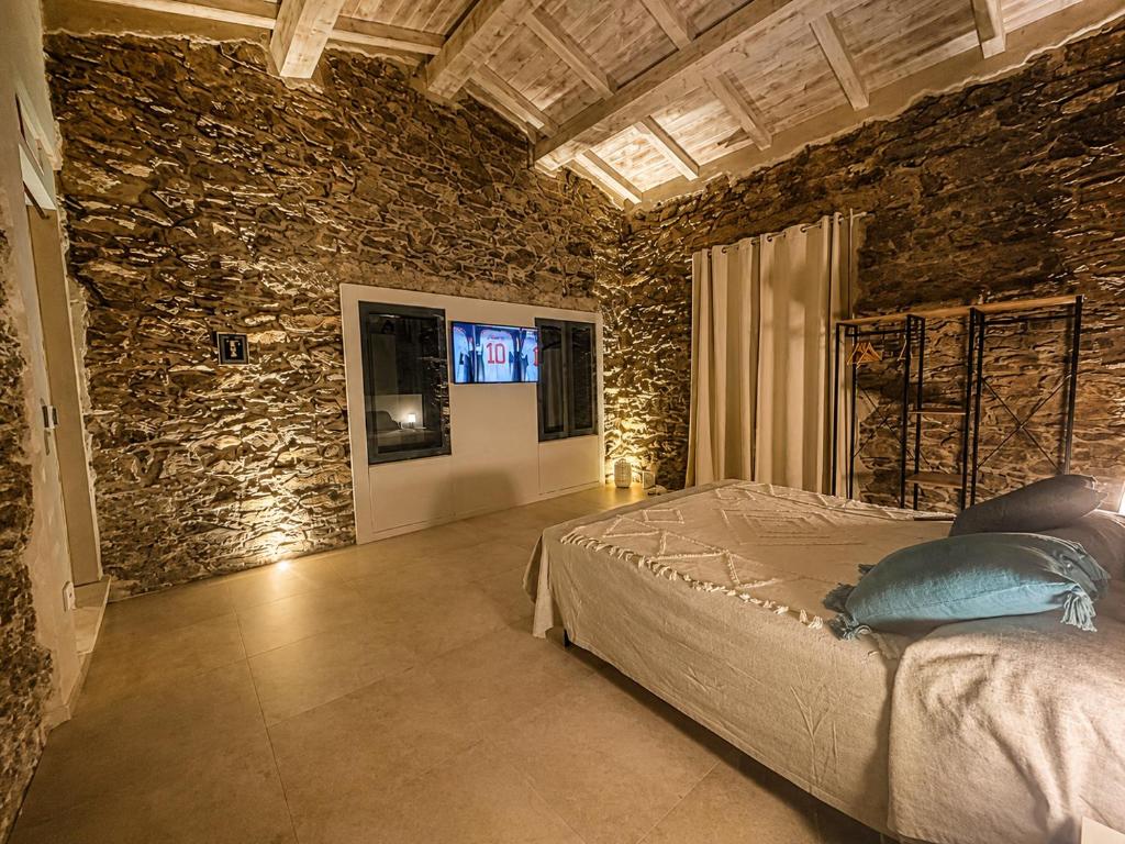 a bedroom with a bed in a stone wall at MP Luxury House in Budoni