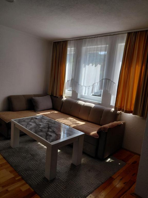a living room with a couch and a coffee table at DM Apartman in Foča