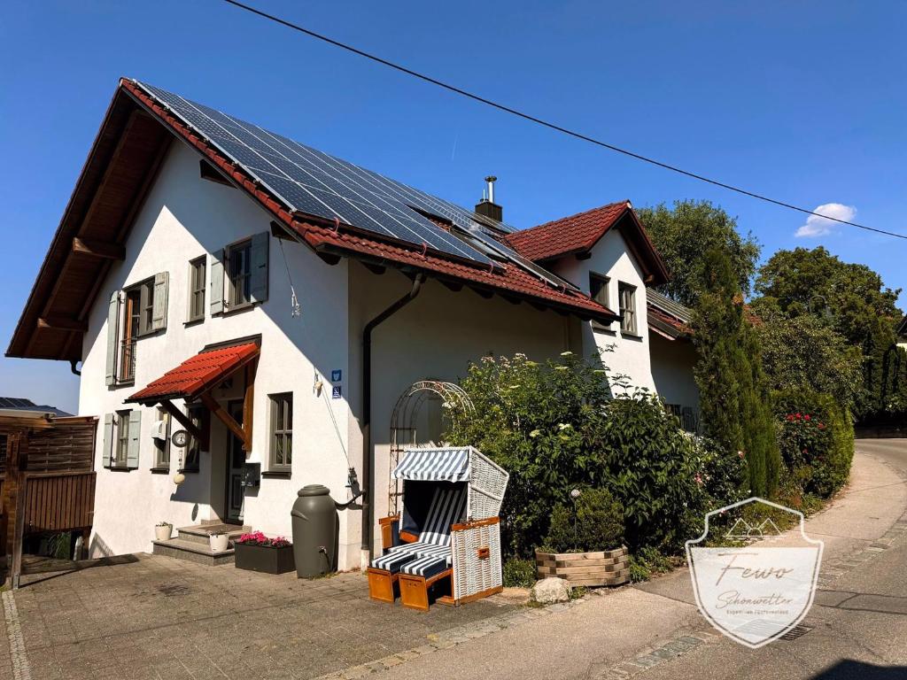 a white house with solar panels on the roof at Ferienwohnungen Schönwetter Oberpfaffenhofen in Weßling