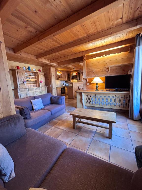 a living room with a couch and a table at Appartement Chez Marion in Notre-Dame-de-Bellecombe