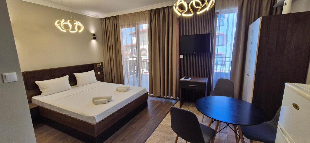a bedroom with a bed and a table and chairs at MitProt Panorama Bay 2 Luks Studio 170 in Sveti Vlas