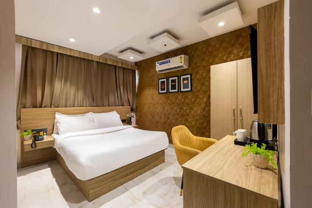 a hotel room with a bed and a desk at Staylo Hotel Azora in New Delhi