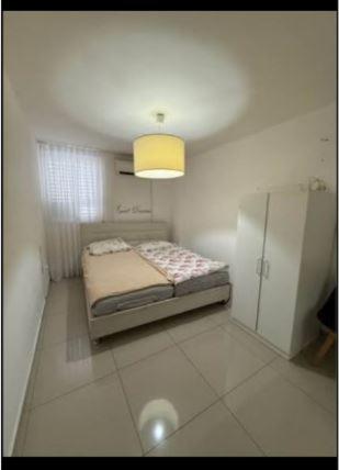 a small bedroom with a bed and a light at בית הארחה דורי 6 in H̱olon