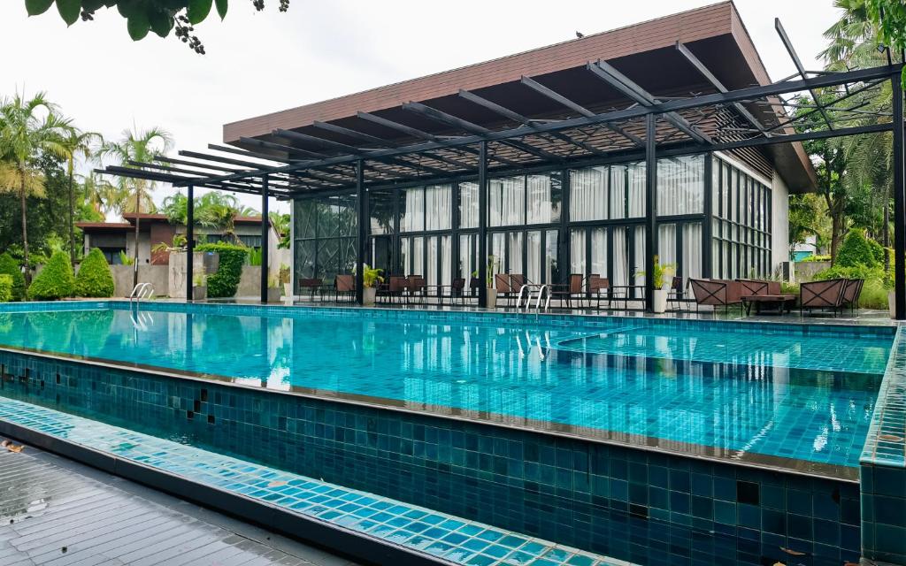 a large swimming pool in front of a building at Sunday Sea Two Pool Villa Pattaya in Jomtien Beach