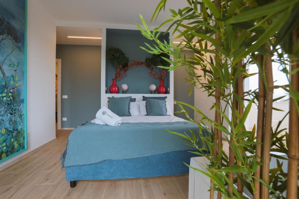 a bedroom with a blue bed and a plant at Dimore Tinè in Castellana Grotte