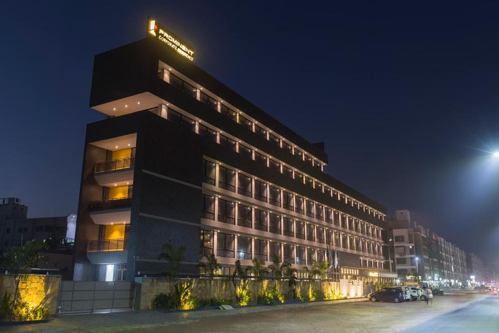 un bâtiment avec un panneau en haut de celui-ci la nuit dans l'établissement Prominent Corporate Residency, à Gandhinagar