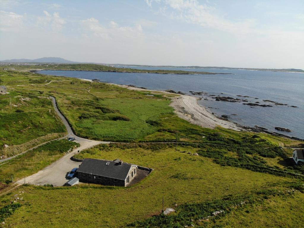an aerial view of a house next to a body of water at Errislannan Stone Cottage in Errislannan