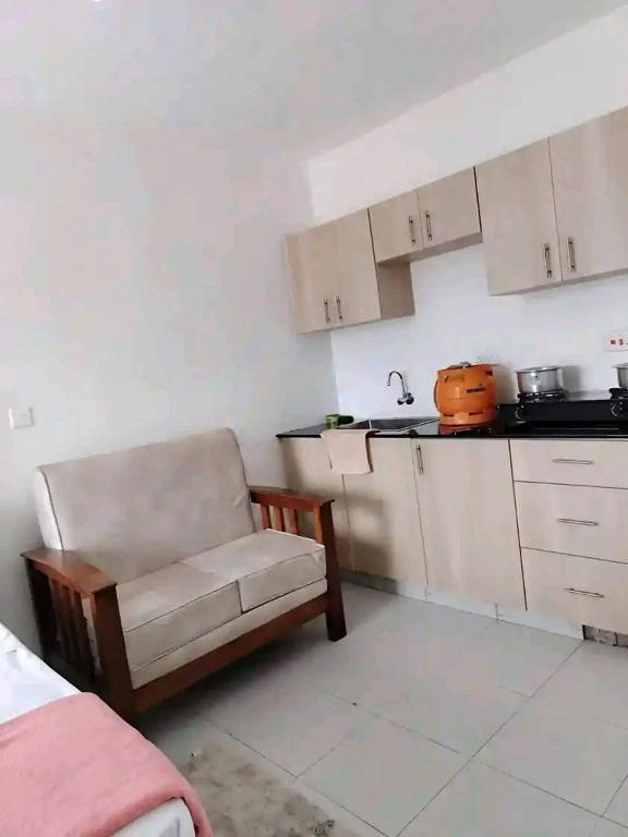 a small kitchen with a chair and a counter at Romantic Cage in Rungiri