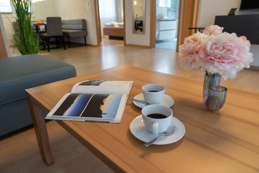 a coffee table with a tablet and two cups of coffee at Bruno in Unterwasser