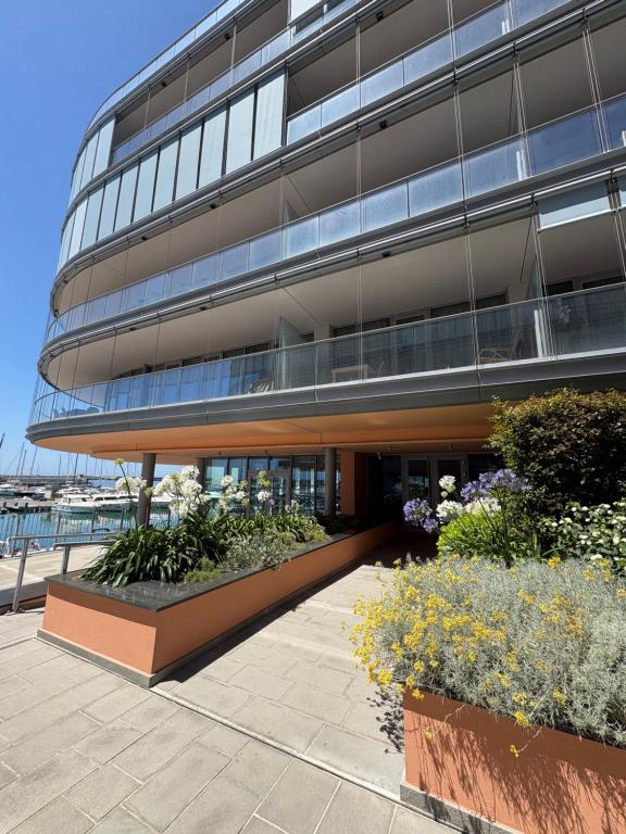 an office building with a garden in front of it at Waterfront Porto Antico House in Genoa