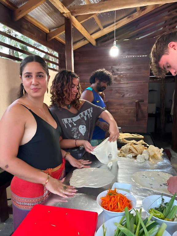 a group of people standing around a table preparing food at Surf and stay A- Bay in Arugam Bay