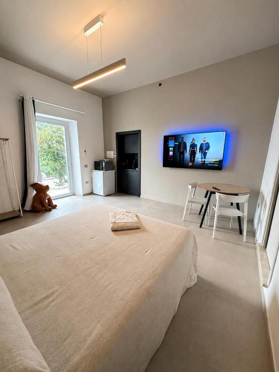 a bedroom with a large bed and a tv on the wall at MP Luxury room in Budoni