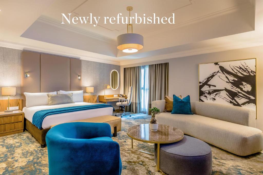 a hotel room with a bed and a couch at Southern Sun Sandton in Johannesburg