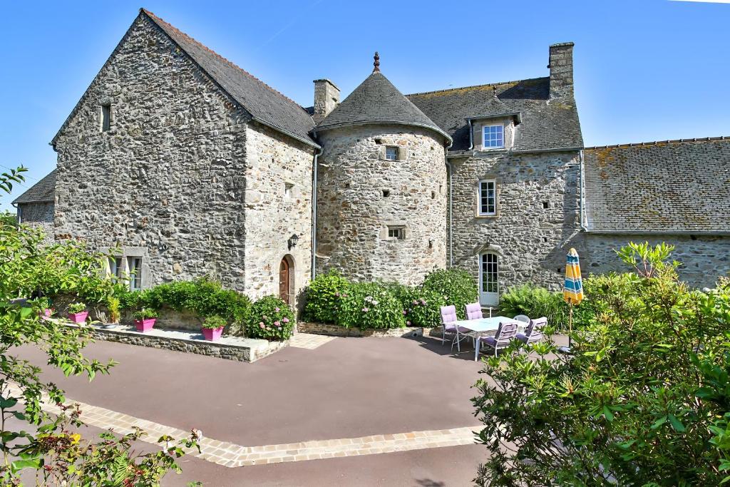 a large stone building with a patio in front of it at Manoir De Labelangerie in Acqueville