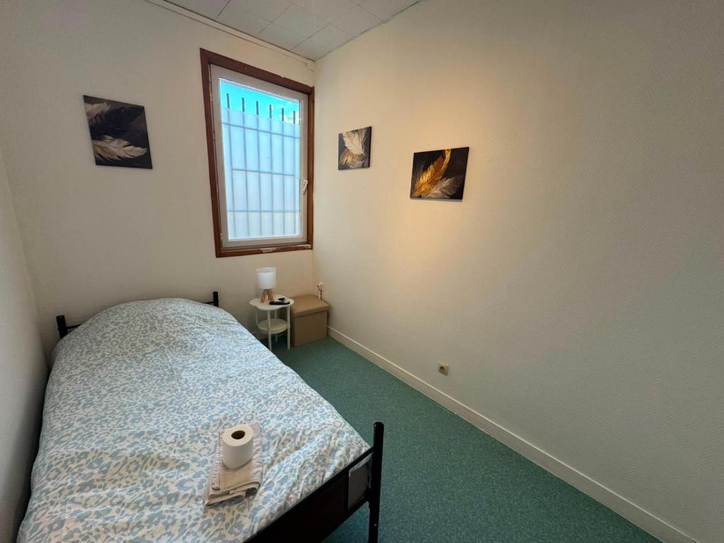 a bedroom with a bed and a window at Le Lotus - 5 in Cherbourg en Cotentin