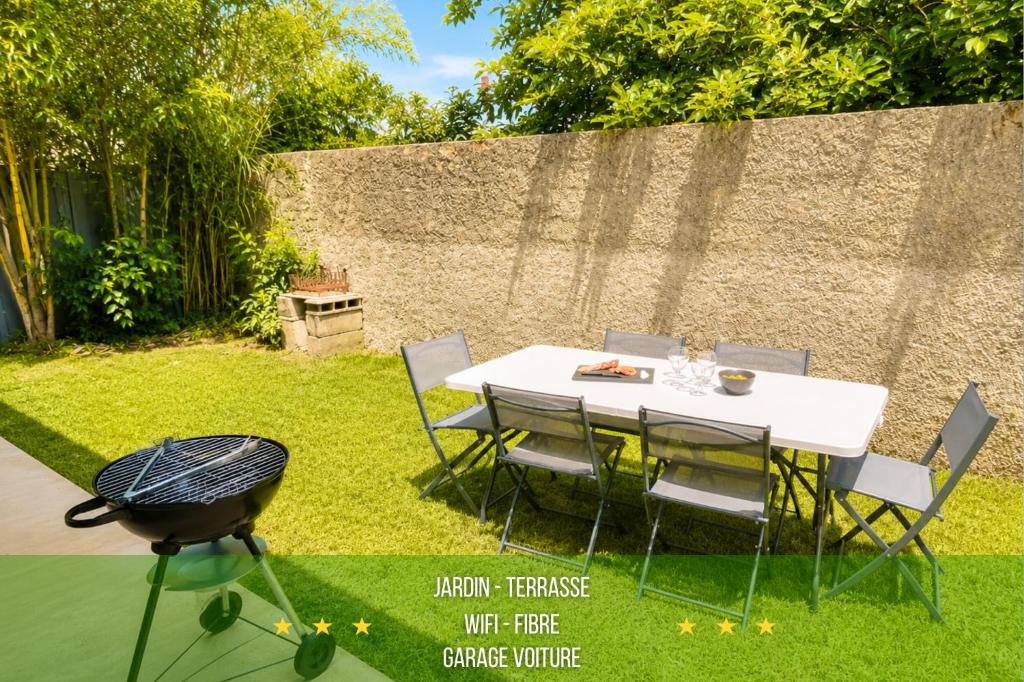 a table and chairs in a garden with a grill at " Parenthèse Verte " Jardin - Barbecue - Garage in Roques Sur Garonne