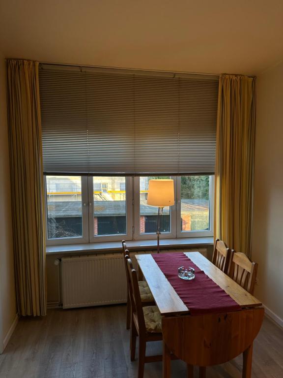 a dining room table with chairs and a large window at Landhaus Gerdts - 2 in Cuxhaven