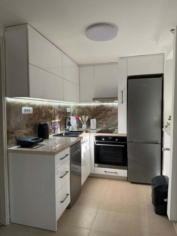 a kitchen with white cabinets and stainless steel appliances at Silver Night in Belgrade