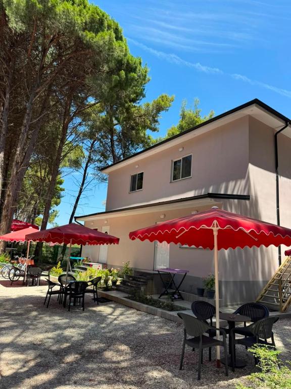 a patio with tables and umbrellas in front of a building at Vila Topi in Vlorë