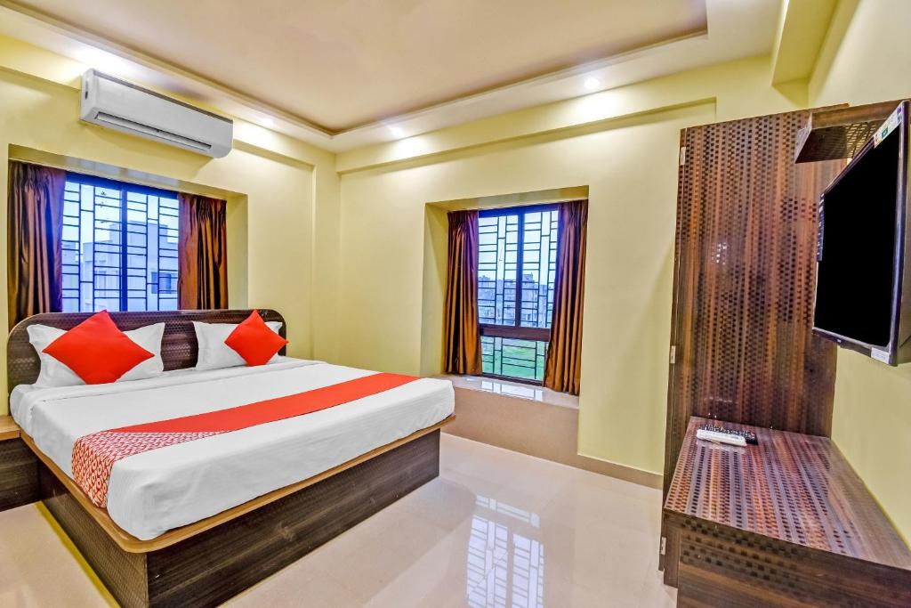a bedroom with a bed and a flat screen tv at Hotel O DOWNTOWN INN in Kolkata