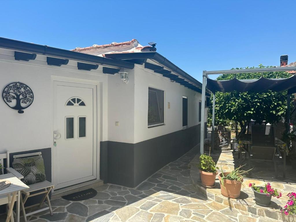 a white house with a patio with plants at Agathe Haus in Stavros