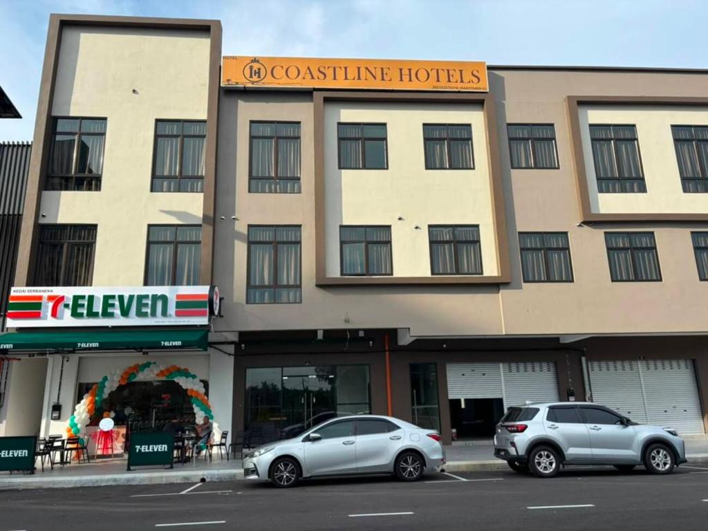 two cars parked in a parking lot in front of a building at Coastline Hotel 6 Avenue PortDickson in Port Dickson