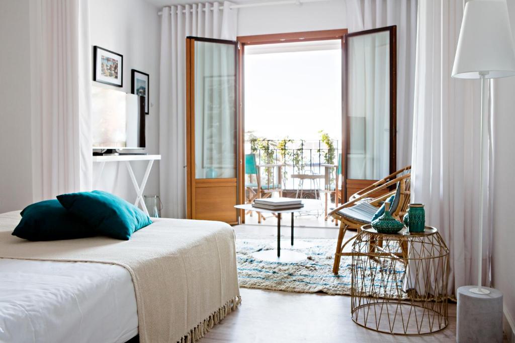1 dormitorio con 1 cama y balcón en CBbC Suites Port Vell, en Ibiza