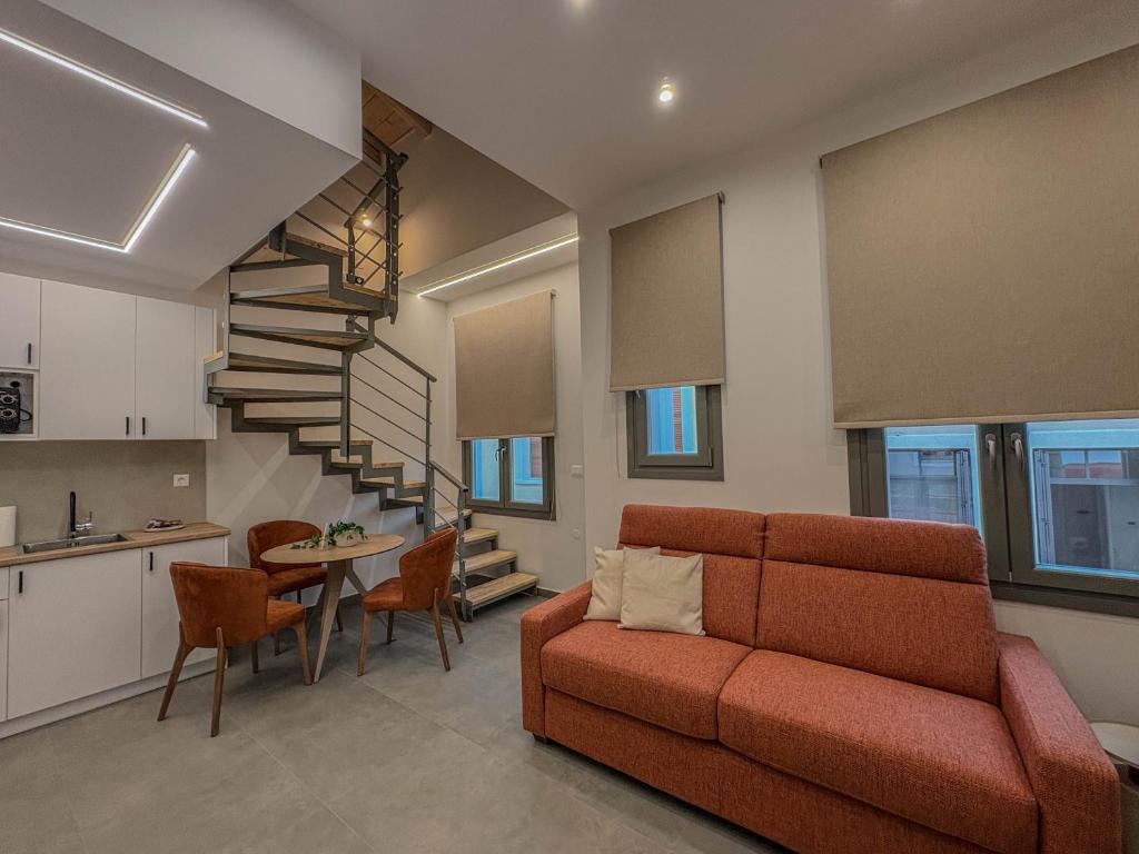 a living room with a red couch and a kitchen at Ralli 34 ROOMS&APTS in Chios