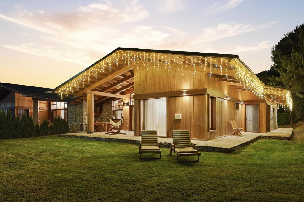 a house with lights and chairs in the yard at Pirin Golf Villa in Bansko